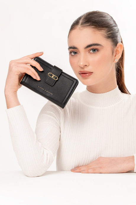 Mujer con suéter blanco sostiene cartera negra elegante con hebilla dorada y texto clásico y moderno