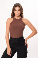 Mujer con top marrón sin mangas y pantalones negros con bolsillos, fondo blanco